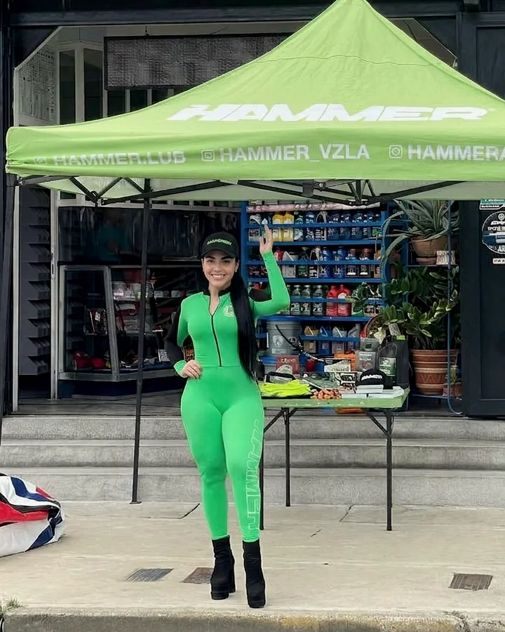 Promotora de ventas en un stand con carpa de marca, lista para atender clientes